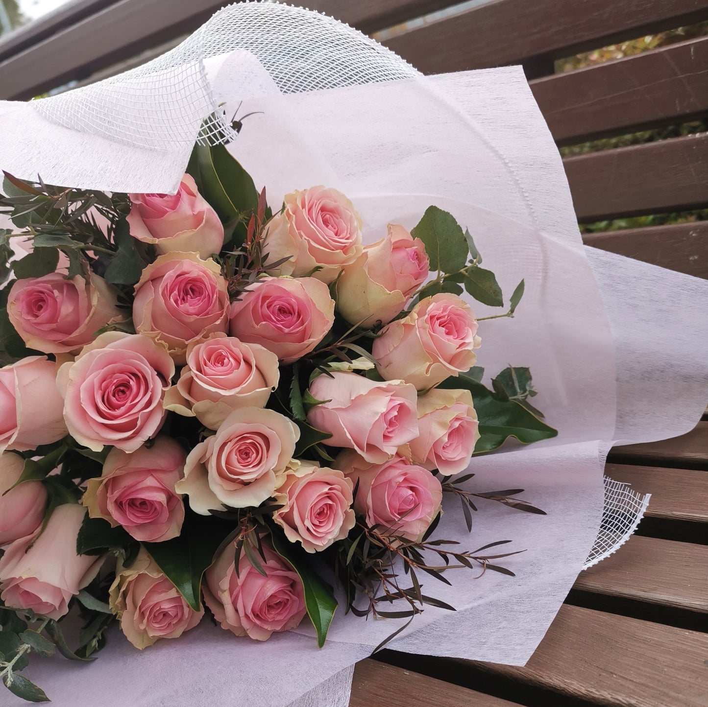 Elegant premium pink roses bouquet resting on a wooden bench prepared for same-day floral delivery across Box Hill.
