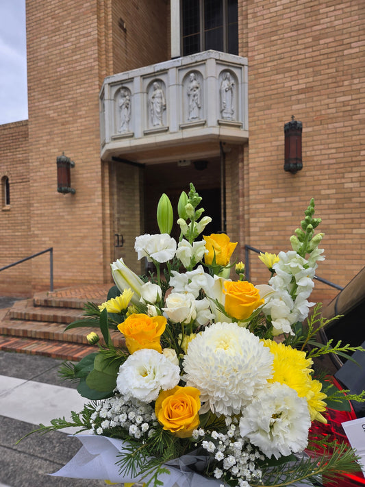 Elegant yellow and white sympathy bouquet for funeral service at Sacred Heart Parish, Croydon, delivered with care by Flowerland.