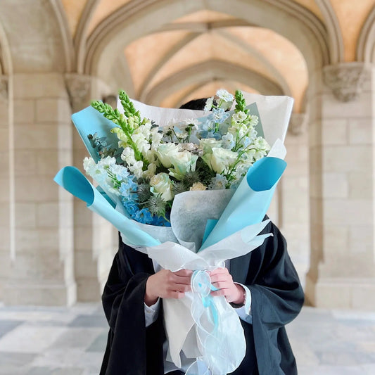 Same-day flower delivery Burwood - Blue and white graduation bouquet with Deakin University clock tower in the background.