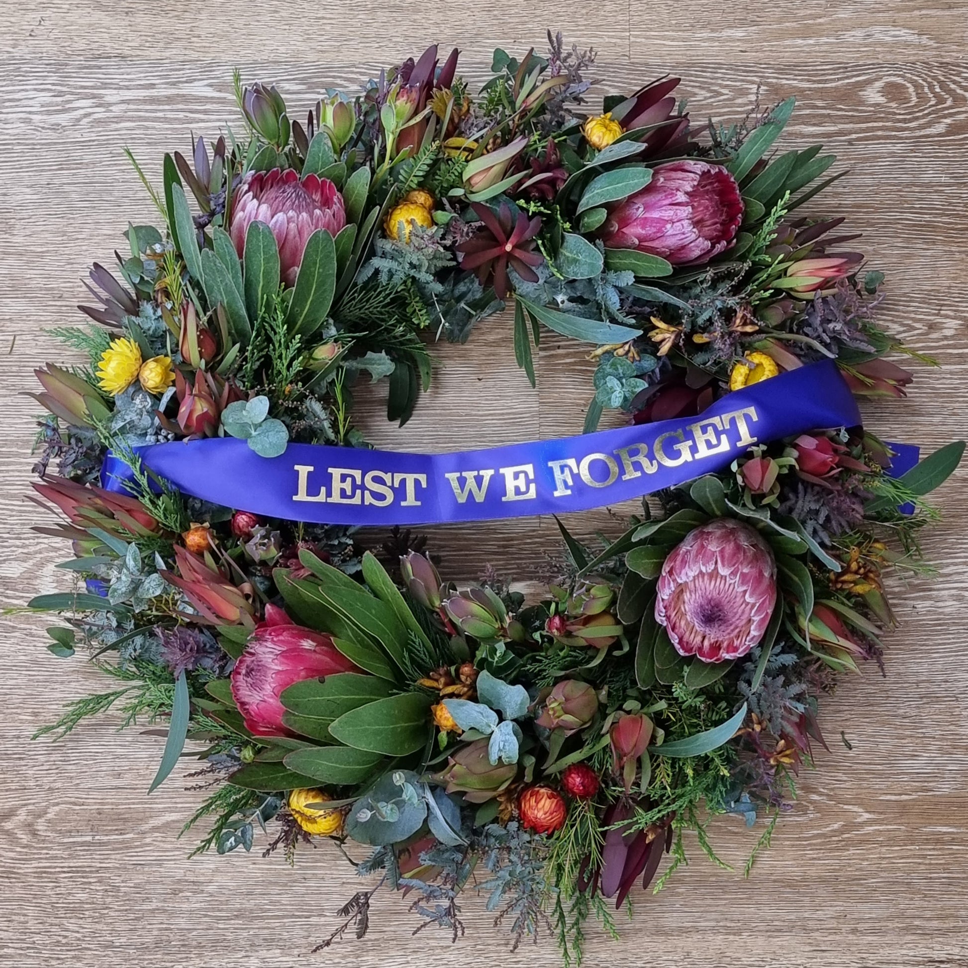 Beautiful ANZAC Day Australian native wreath with proteas, banksias, gum leaves and Lest We Forget ribbon | Fresh handcrafted memorial flower wreath | Flowerland Nunawading