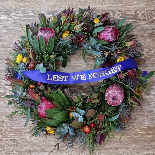 Beautiful ANZAC Day Australian native wreath with proteas, banksias, gum leaves and Lest We Forget ribbon | Fresh handcrafted memorial flower wreath | Flowerland Nunawading