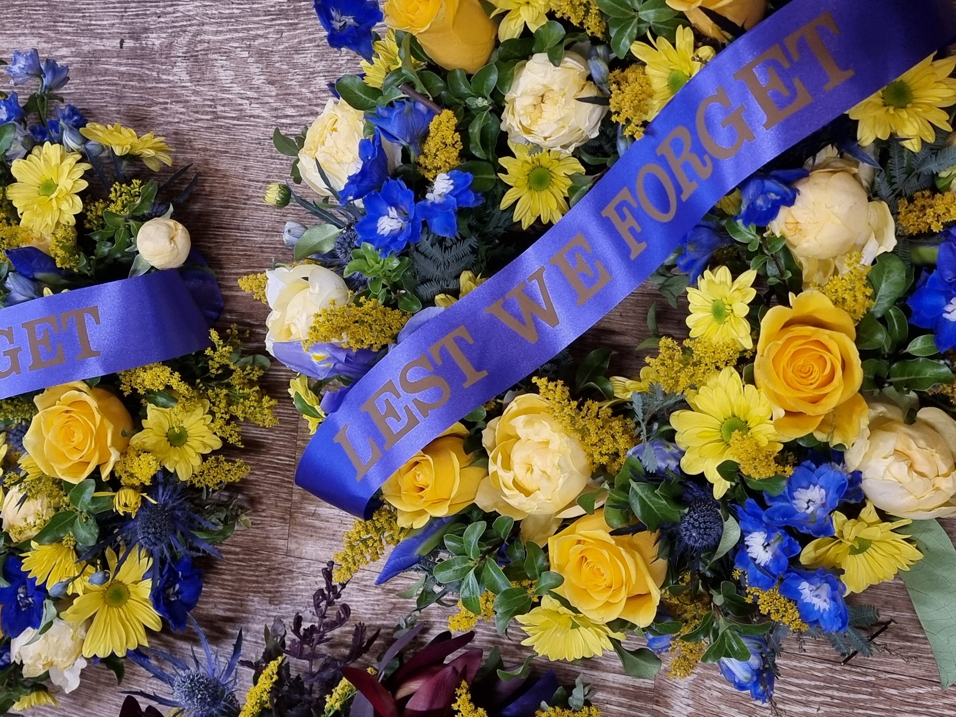 Bright yellow and blue ANZAC Day wreath with Australian native flowers and Lest We Forget ribbon | Memorial tribute | Flowerland Nunawading