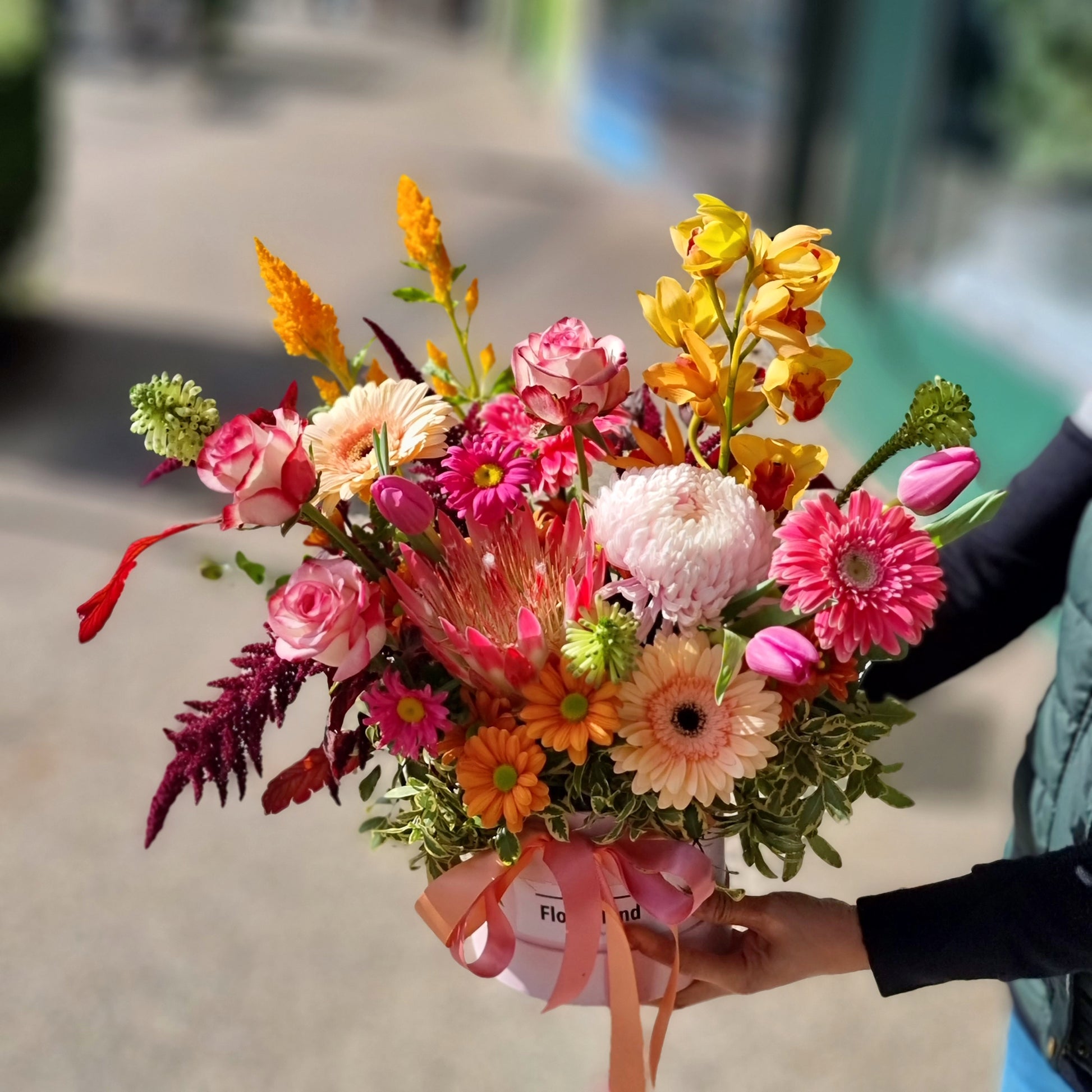 Vibrant bespoke hatbox floral arrangement with bright gerberas and yellow flowers & roses for same-day delivery in Camberwell.