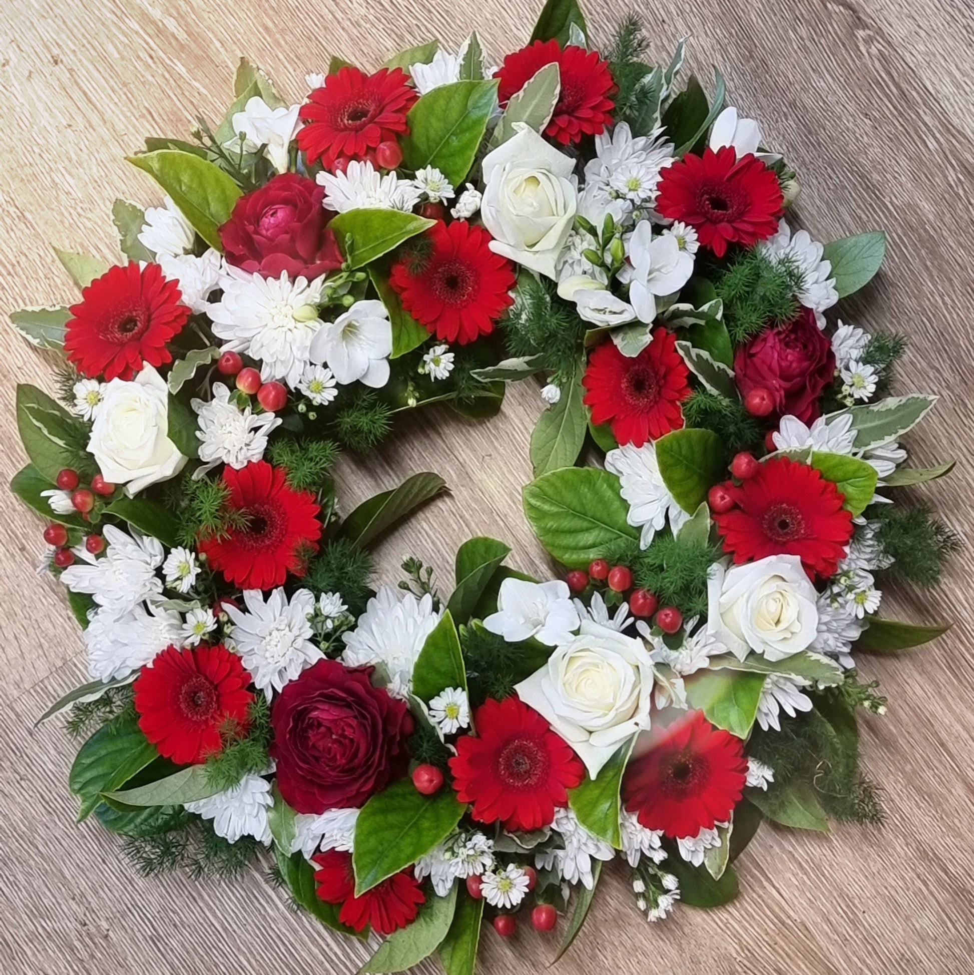 Traditional round Fresh Flower Wreath featuring a respectful mix of fresh red and white blossoms with rich green foliage same-day delivery The Flowerland Nunawading
