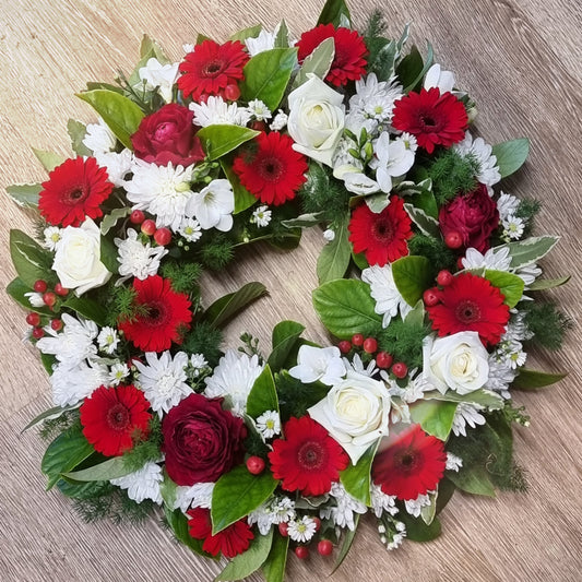 Traditional round Fresh Flower Wreath featuring a respectful mix of fresh red and white blossoms with rich green foliage same-day delivery The Flowerland Nunawading