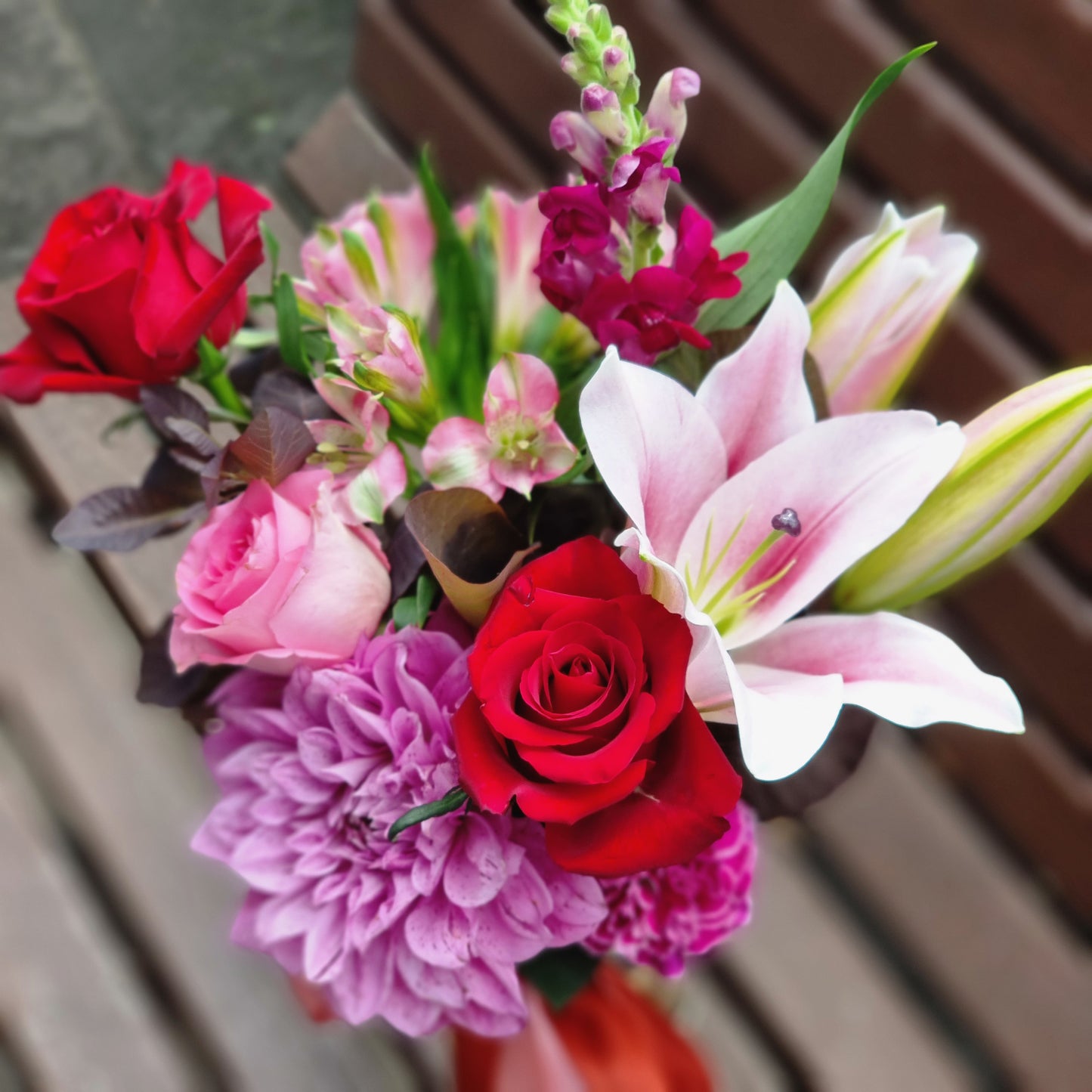 Detailed close up view of fresh sweet love purple and red blossoms with burgundy foliage delivered same-day to premium apartments in Glen Waverley.