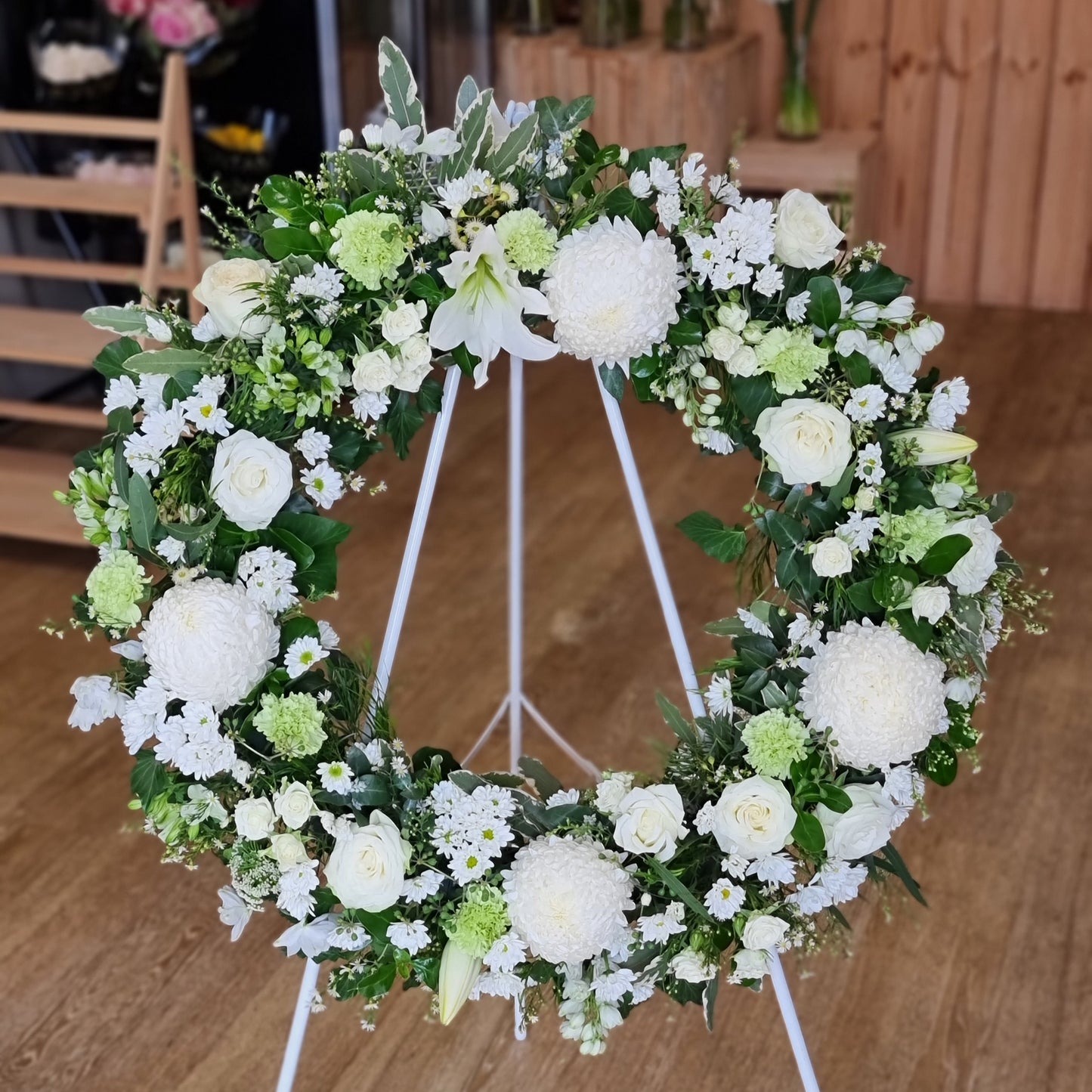 Elegant Funeral Wreath White featuring premium pure white blossoms and structured green foliage on a standing easel for same-day sympathy delivery The Flowerland Nunawading