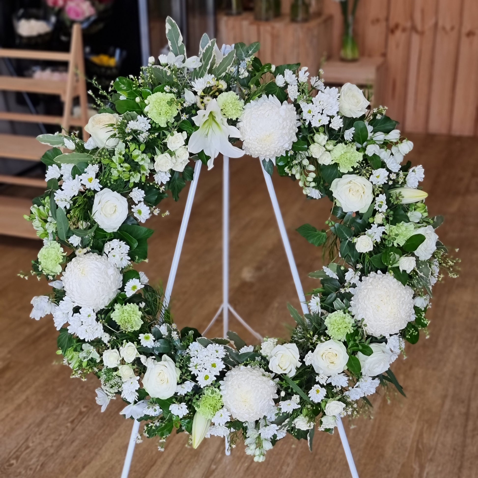 Elegant Funeral Wreath White featuring premium pure white blossoms and structured green foliage on a standing easel for same-day sympathy delivery The Flowerland Nunawading