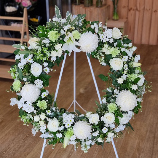 Elegant Funeral Wreath White featuring premium pure white blossoms and structured green foliage on a standing easel for same-day sympathy delivery The Flowerland Nunawading