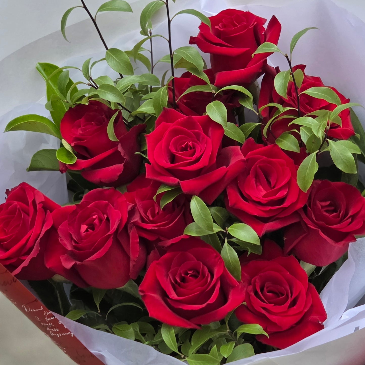 Detailed top view of premium Valentine's Day red roses nestled in wrapping paper ready for same-day delivery to Glen Waverley.