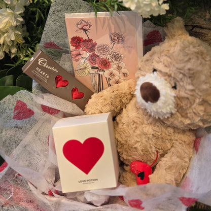 Sweety Hamper contents including a teddy bear, Pinkmint love potion candle, Chocolatier red love hearts chocolates and greeting card in gift box | flowerland.