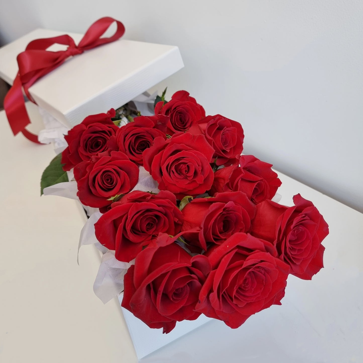 Premium long stem red roses arranged in an elegant luxury white gift box with red satin ribbon same-day delivery The Flowerland Nunawading