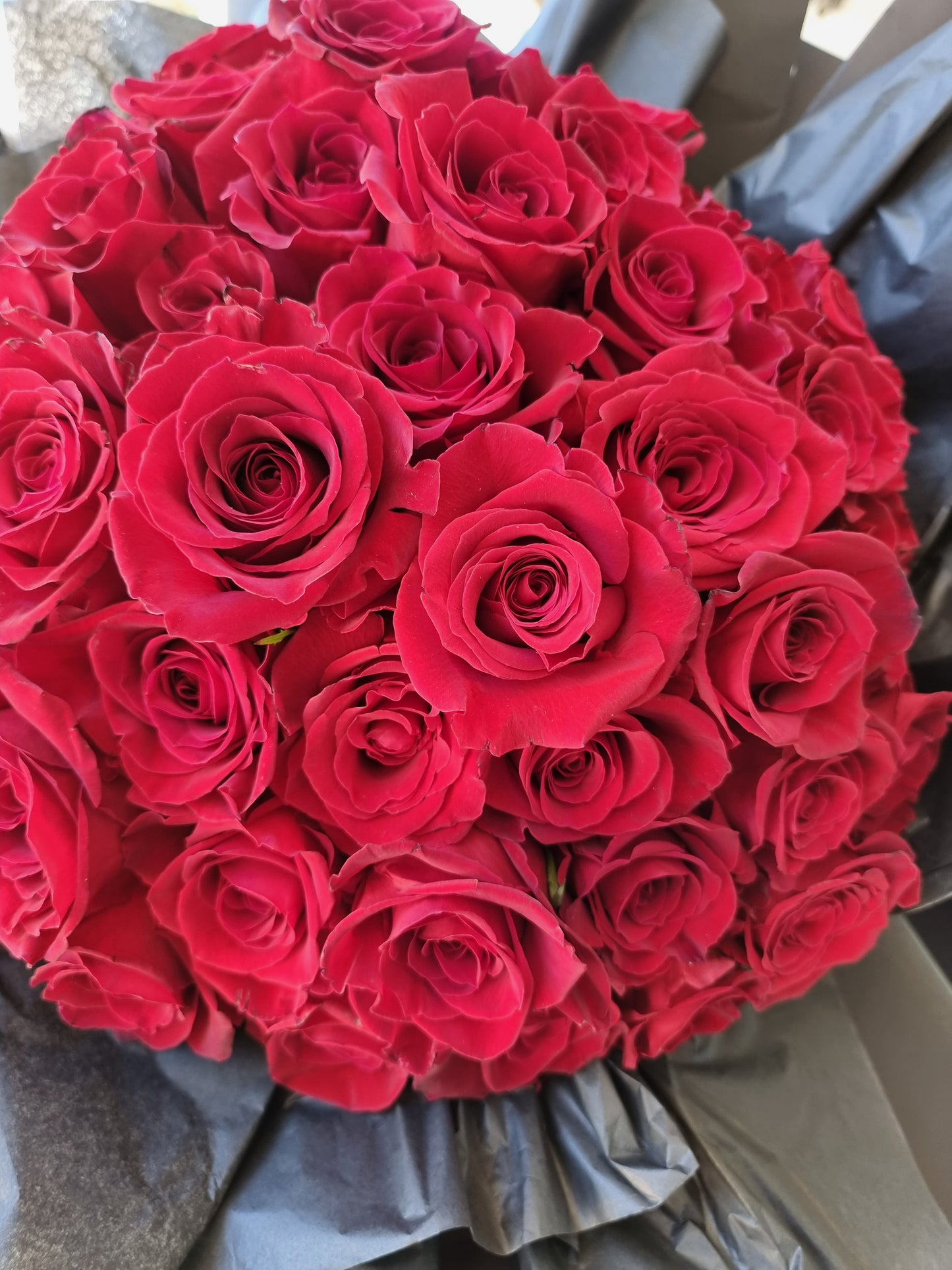 Bountiful top view of premium red roses arrangement packed meticulously for courier delivery to Doncaster.
