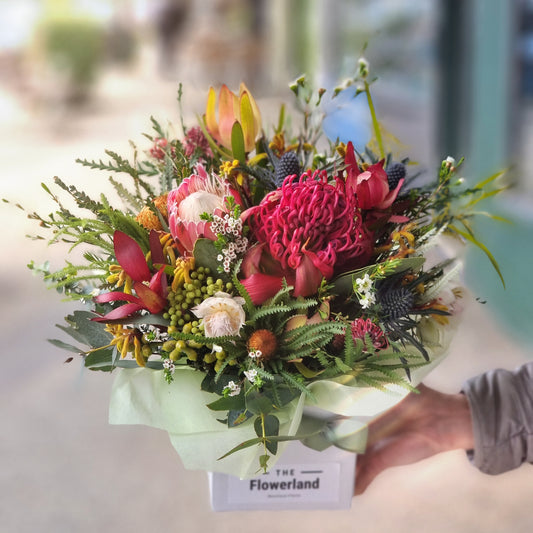Rustic native box flower arrangement featuring large red protea and mixed Australian wildflowers same-day delivery Flowerland Nunawading