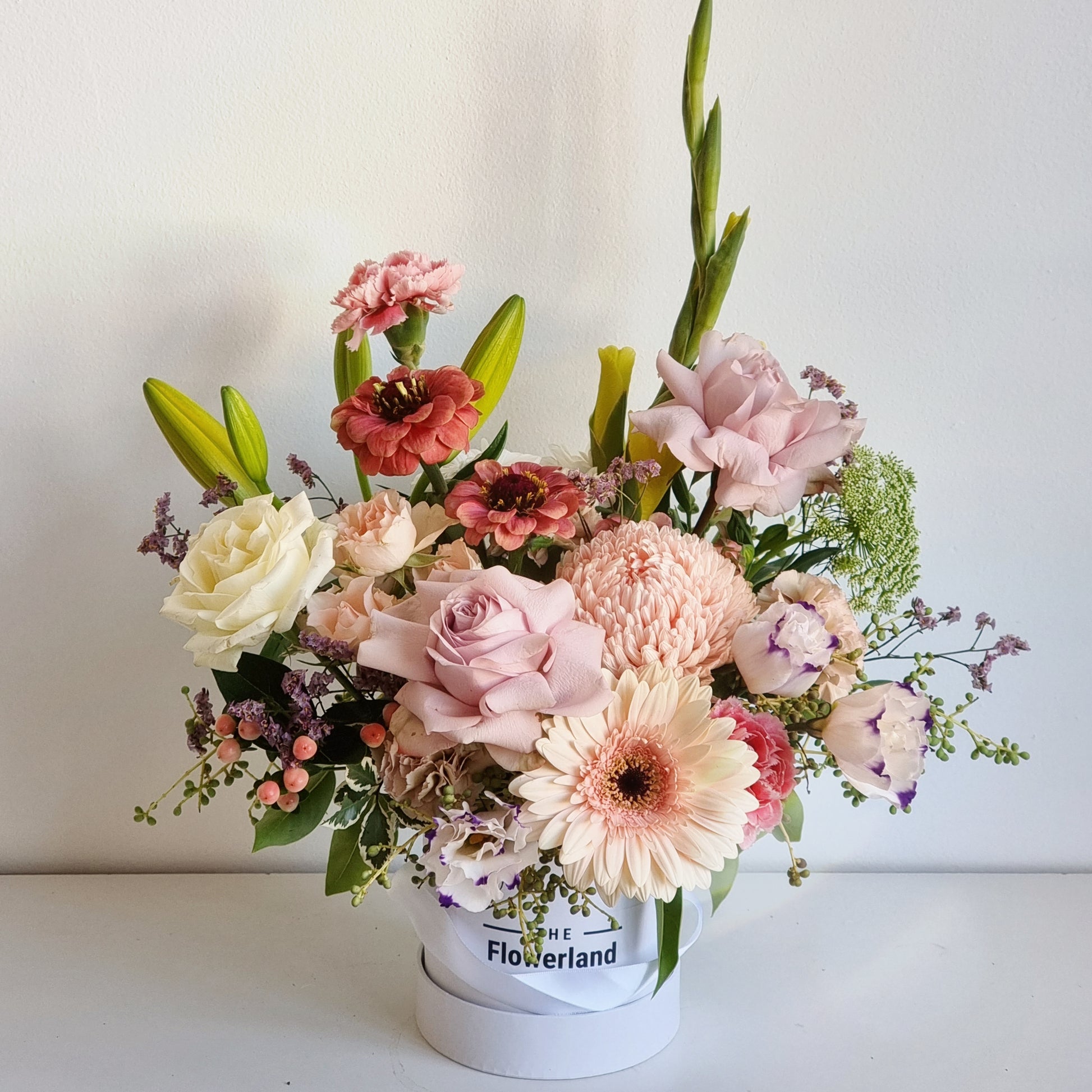 Luxury bespoke hatbox arranged with fresh white lilies and blush pink roses delivered straight to Surrey Hills homes.