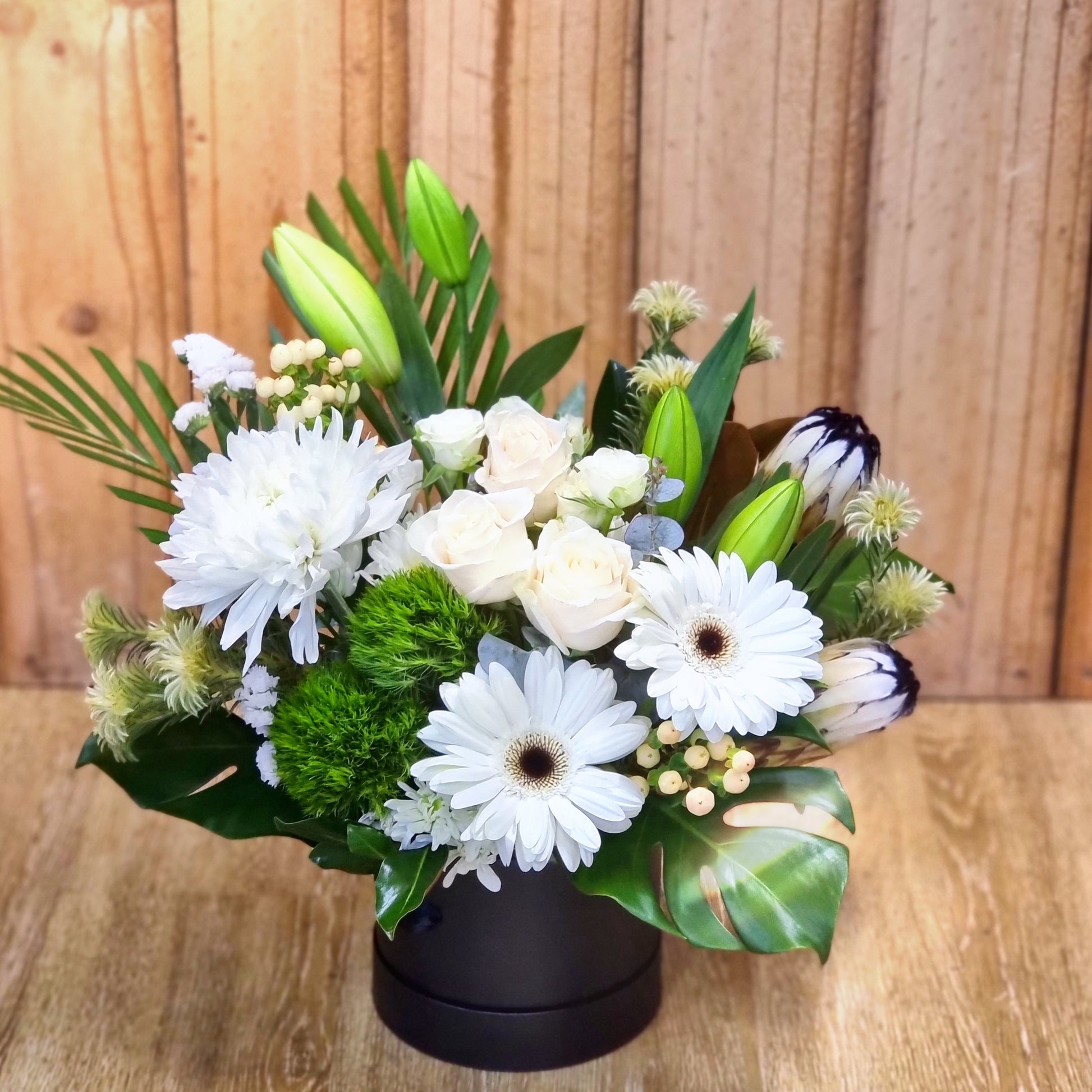 Sophisticated white roses and snapdragons in a modern black hatbox ready for temperature-controlled transit to Doncaster.